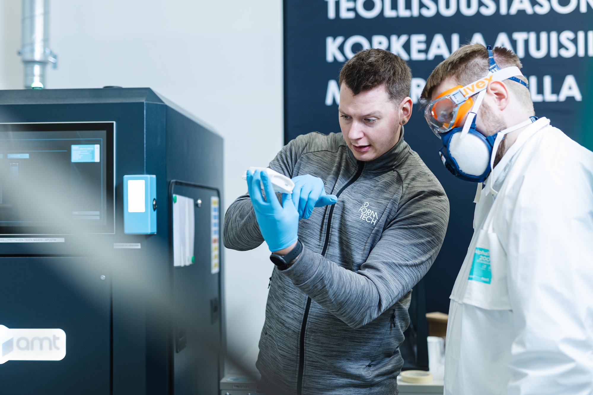 Kuvassa 3D Formtechin asiantuntjiat tutkivat 3D-tulostetta.